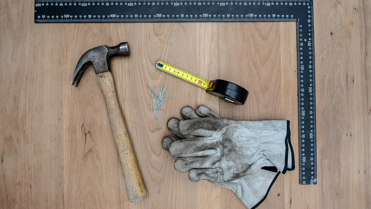 Cheap handyman services near me: what to expect and how to compare Hammer, tape measure, gloves, and framing square on wood